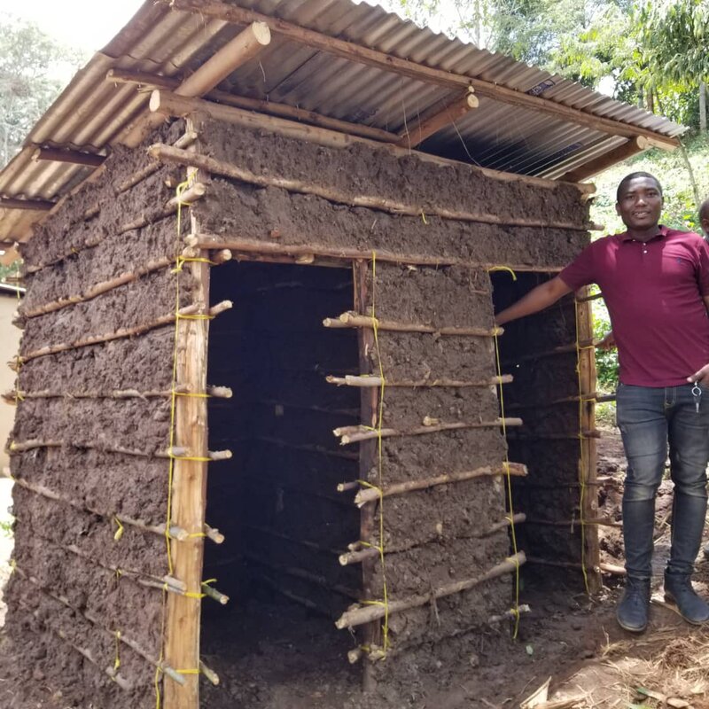 Mr. Hussein in front of the poor old toilet to be rebuilt.